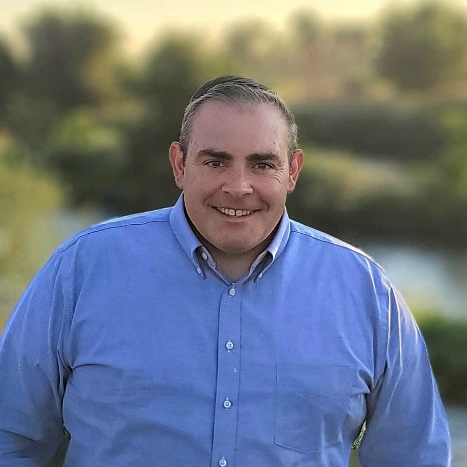 Adams County Commissioner Steve O'Dorisio smiling outdoors in a blue shirt